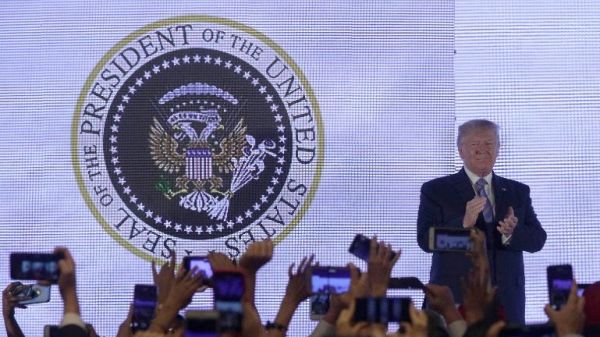 美国总统特朗普23日出席活动演讲时,背后的总统徽章竟然是嘲讽他的视觉设计作品,美国白头雕被改成近似俄罗斯国徽的双头鹰,两只鹰爪分别抓着高尔夫球杆和美钞现金。(台湾联合新闻网)
