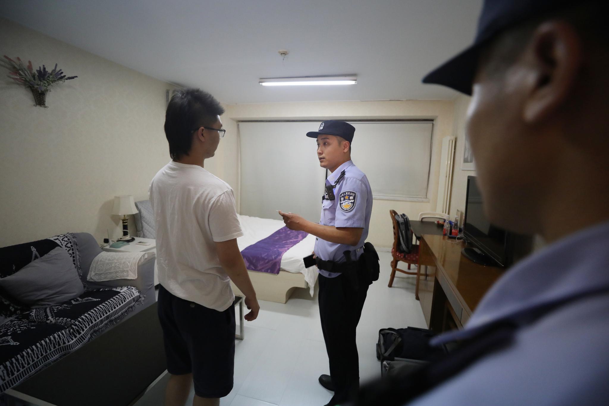 民警对住户进行询问。新京报记者 王飞 摄