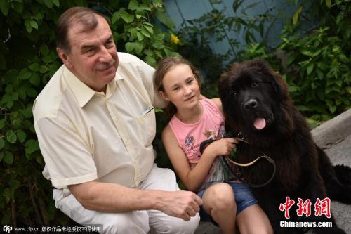 资料图：2015年7月，一个吉尔吉斯斯坦小女孩，收到普京赠送的一条纽芬兰犬。