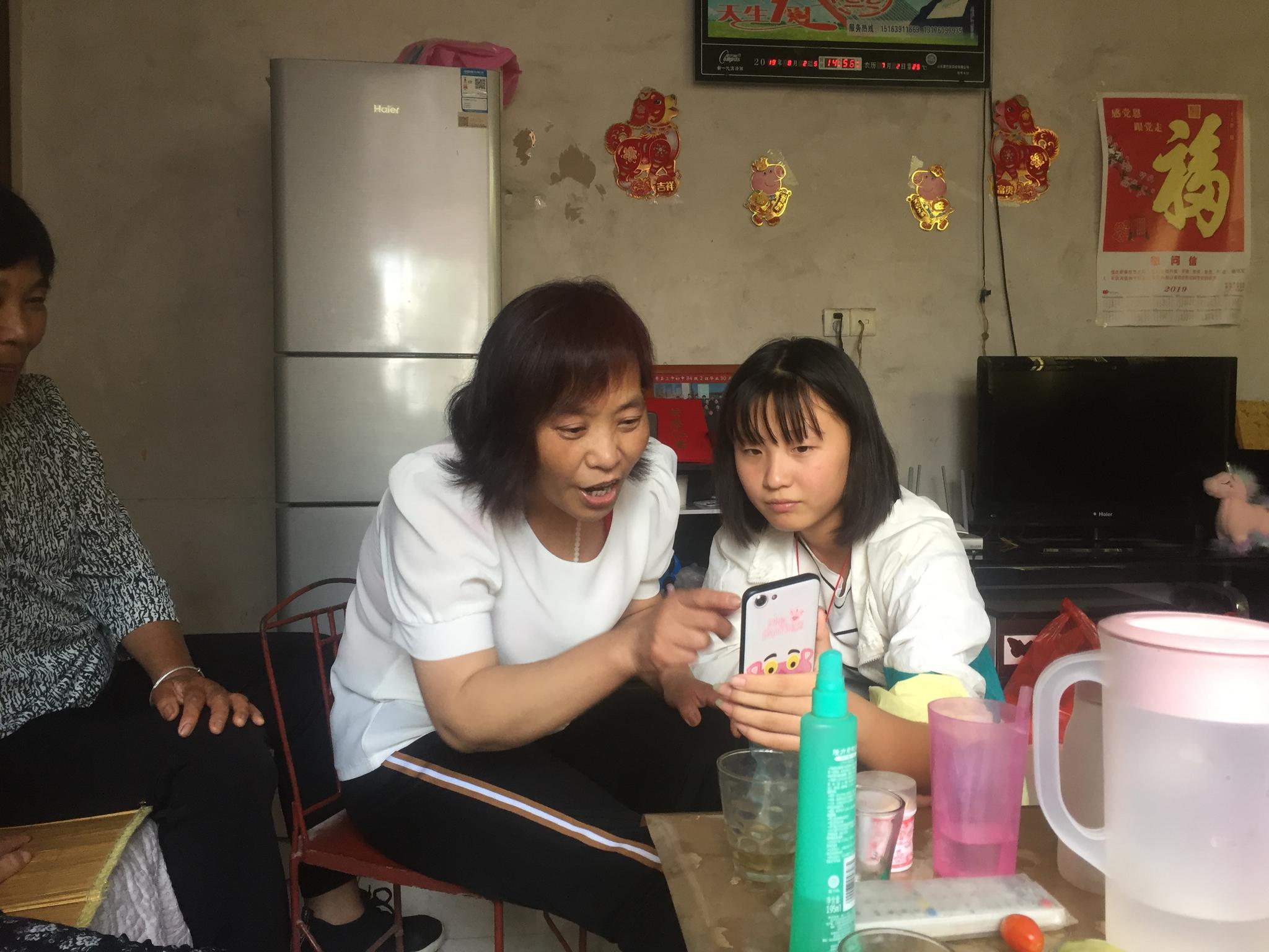 8月2日下午，任艳红在女儿的指导下和朋友微信视频。 新京报记者 赵朋乐 摄
