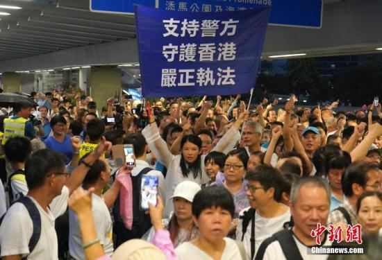 　7月20日下午，30余万香港市民在金钟添马公园参加“守护香港”集会，共同守护香港法治的核心价值，维护法治，反对暴力。图为集会结束后，一名市民高举支持警方的横幅，市民纷纷竖起大拇指，高喊“支持警察”的口号。中新社记者 张炜 摄