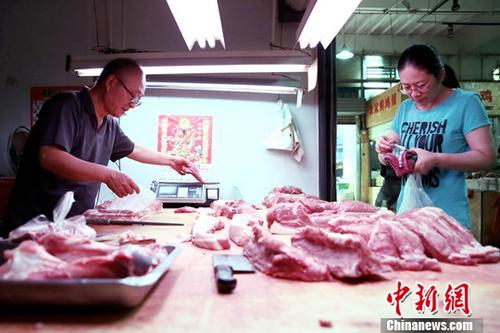 资料图：西安民众于菜市场内购买猪肉。中新社记者 张远 摄