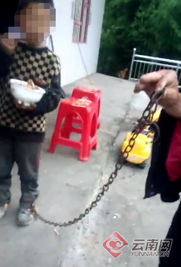 　小男孩脚被铁链锁住的视频截图。
