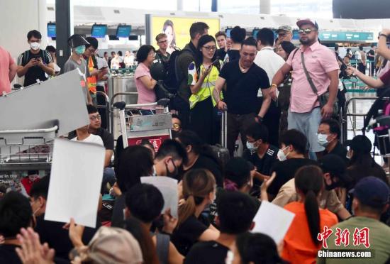  8月13日下午，大批示威者以机场手推车等堵塞香港国际机场1号客运大楼旅客登机行段及保安闸门，旅客未能经1号客运大楼前往离境大堂。中新社记者 麦尚旻 摄