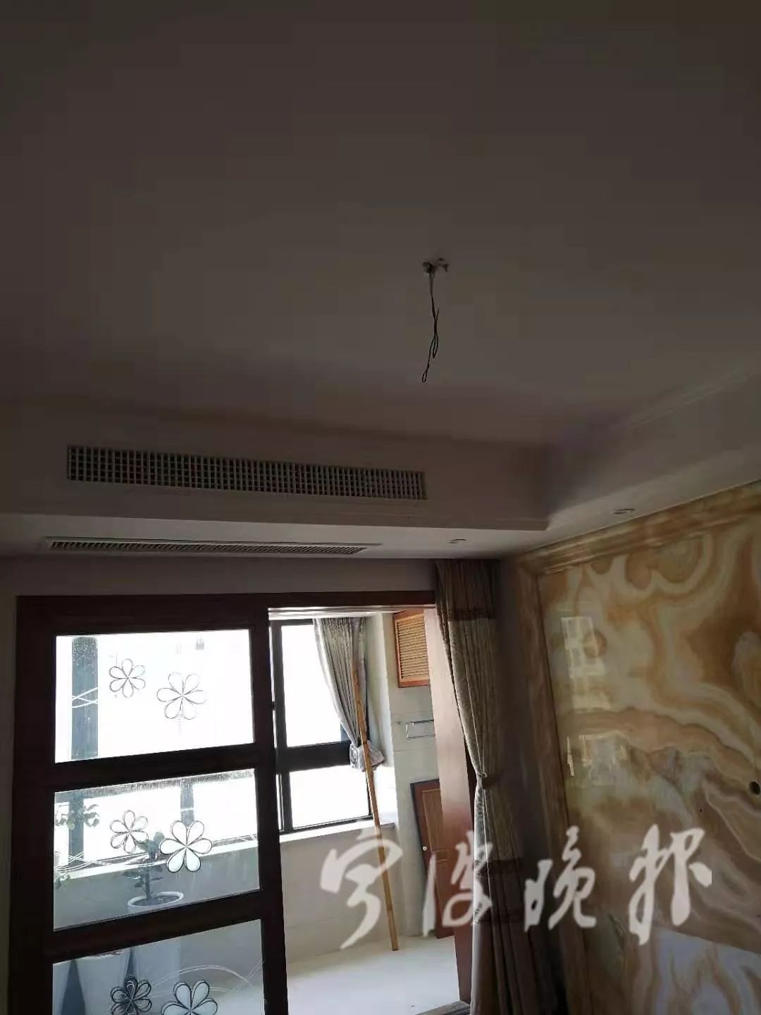 客厅的吊灯被拆走,只剩电线