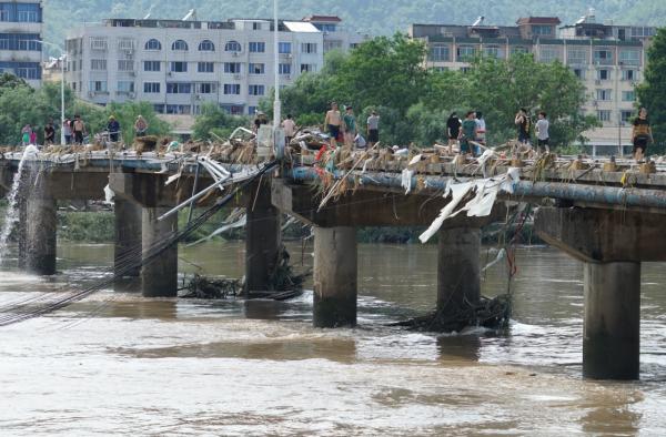 临海一座桥上挂满了洪水冲来的垃圾（8月11日摄）。8月10日下午，超强台风“利奇马”引发的洪水围困浙江临海。 新华社 图