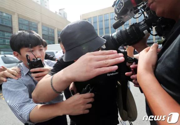 24日，涉案男子接受调查，被媒体围堵（韩联社）