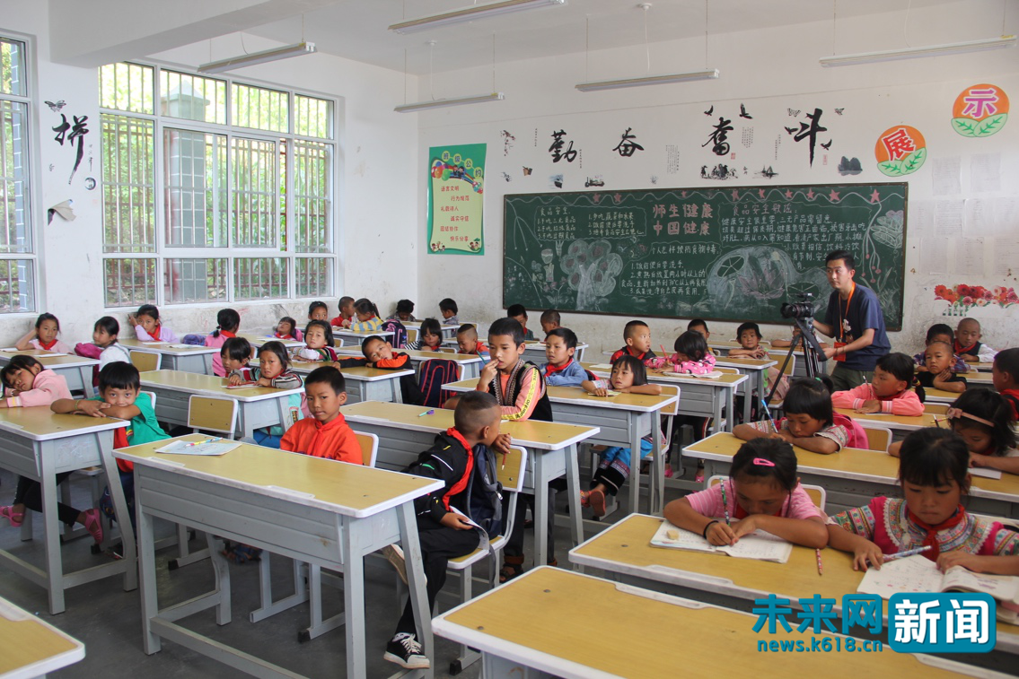 图为哈阿希望小学开学第一天,孩子们在教室里上第一节课.