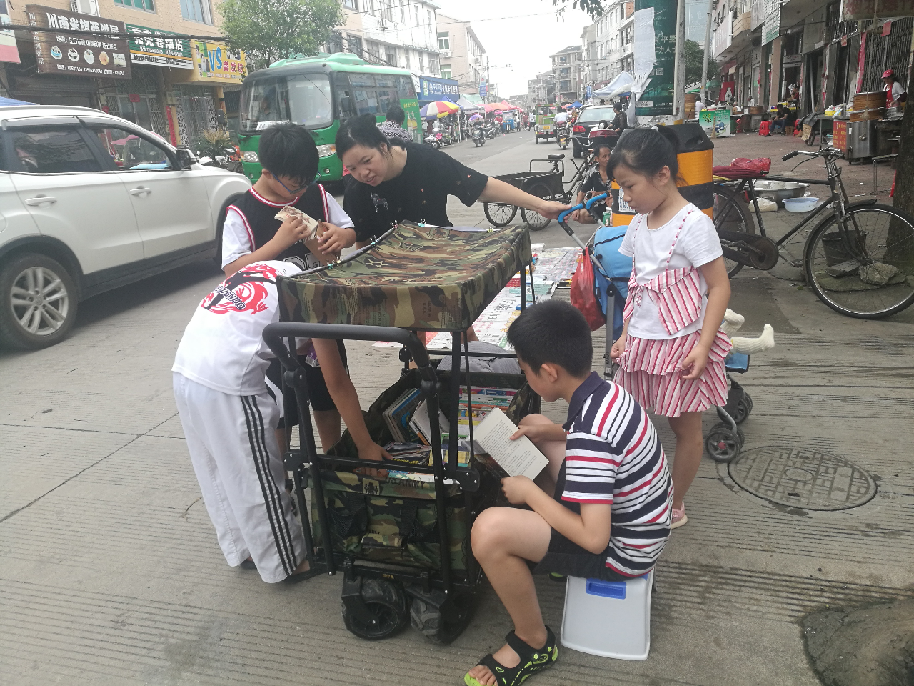 城市小男孩乡下摆书摊 600本书街头免费看 大人都吸引过来