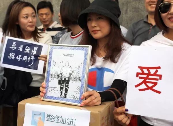▲8月9日，香港市民齐集香港警察总部门外，为警方送上物资和心意卡，其中还包括一幅由内地网民创作的“刘Sir背影”漫画。（新华社）