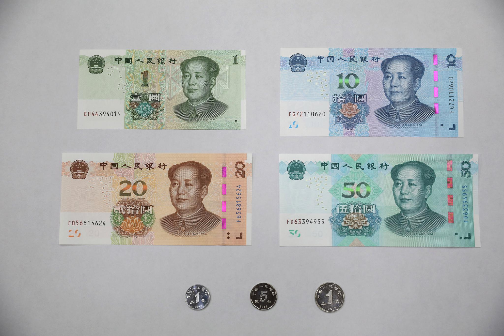 中国工商银行的工作人员向记者展示新版人民币两位中老年市民在交通