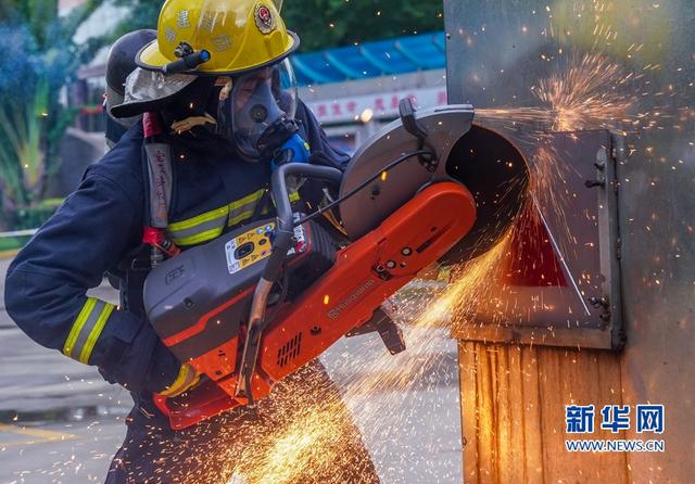 这是纵深灭火救人比赛的第一个操作程序,消防员用无齿锯破门(9月5日摄