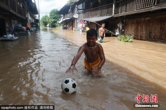泰国洪水:泰国多地遭洪灾逾37万户家庭受影响 已导致28人死 当地时间9月3日,泰国披集府,男孩们在被洪水淹没的菲契特街上玩足球。图片来源:Sipaphoto 版权作品 禁止转载