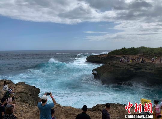 很多游客常常不听劝阻，跑到崖石边拍照。　赖洪元 供图