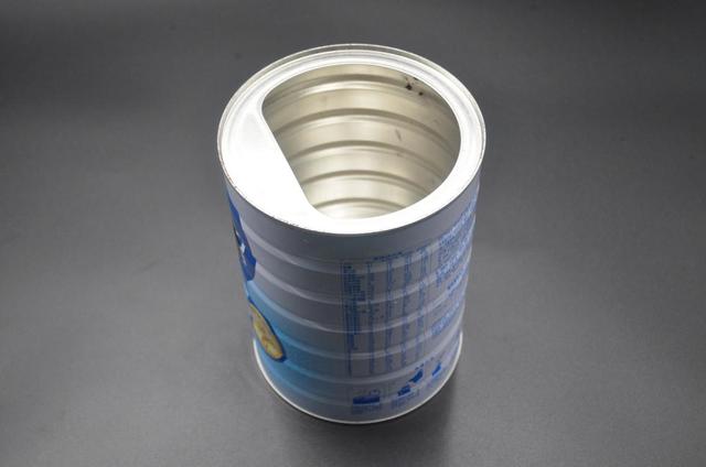 首先准备一个空的奶粉罐子,用工具在奶粉罐子的侧边中间部分戳2个小洞