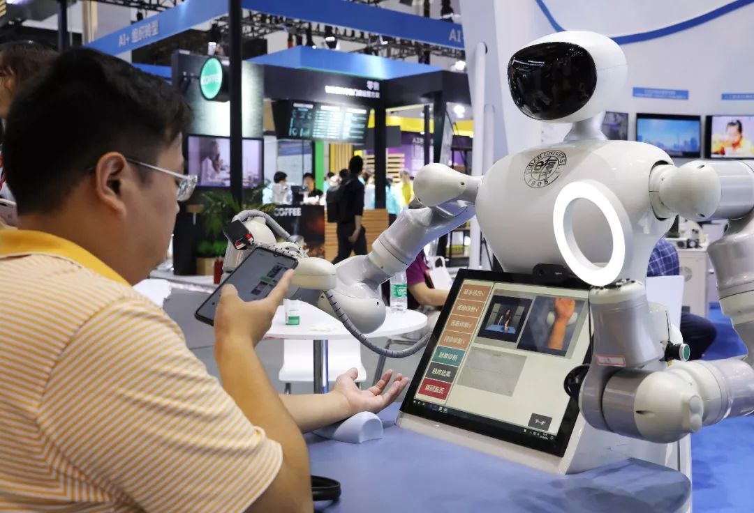 ▲在2019世界人工智能大会上，一名参观者拍摄一款自主交互中医四诊机器人的“看病”过程。（新华社）