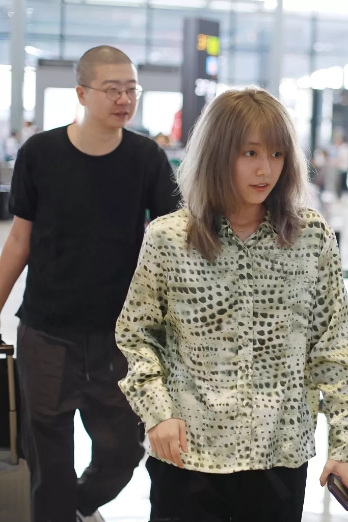 李诞夫妻罕见合体走机场,90后黑尾酱染银发显龄,素颜五官太精致