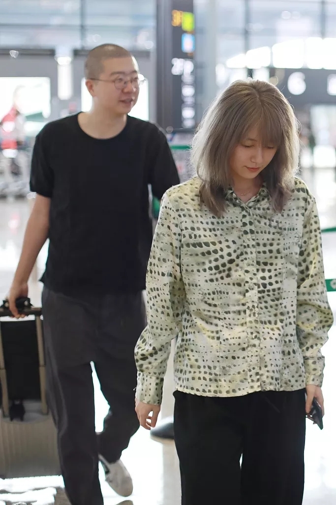 李诞夫妻罕见合体走机场,90后黑尾酱染银发显龄,素颜五官太精致