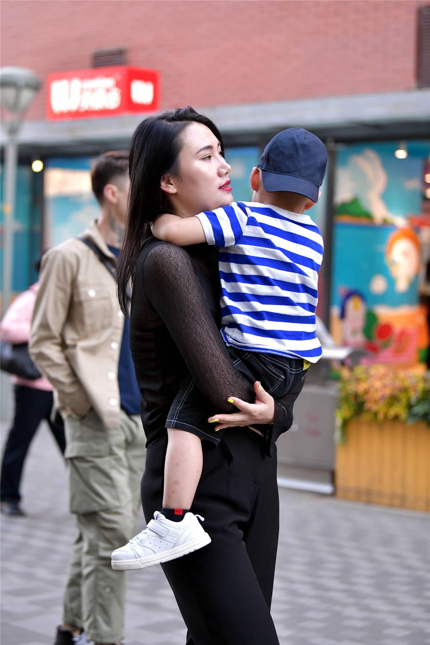 平时拧瓶盖都费劲的时尚辣妈抱起自己的孩子却毫不含糊