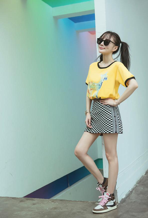 李小璐穿黄色t恤黑白格纹短裙,双马尾配齐刘海发型,活力俏皮