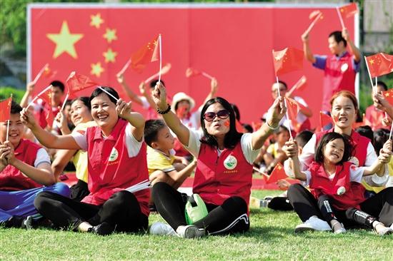 市民在巨幅国旗前挥舞小国旗 中山日报记者余兆宇 实习生陈家浩摄