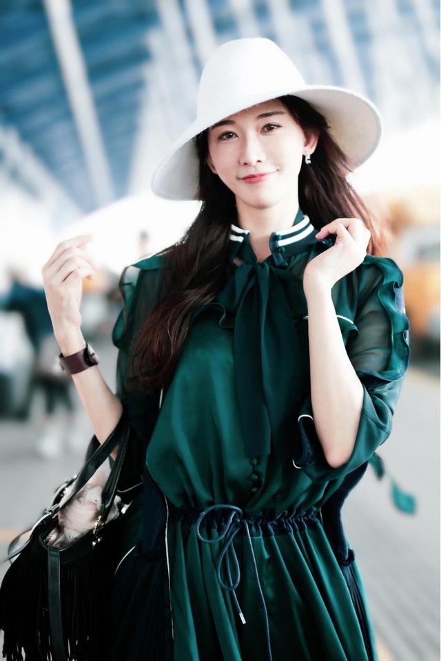 林志玲穿墨绿色连衣裙配白色帽子走机场