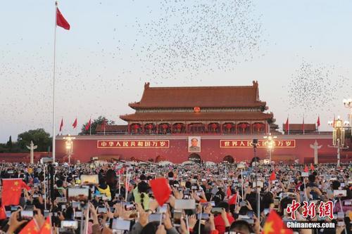 资料图:民众到天安门广场观看升旗仪式并唱响国歌。中新社记者 盛佳鹏 摄
