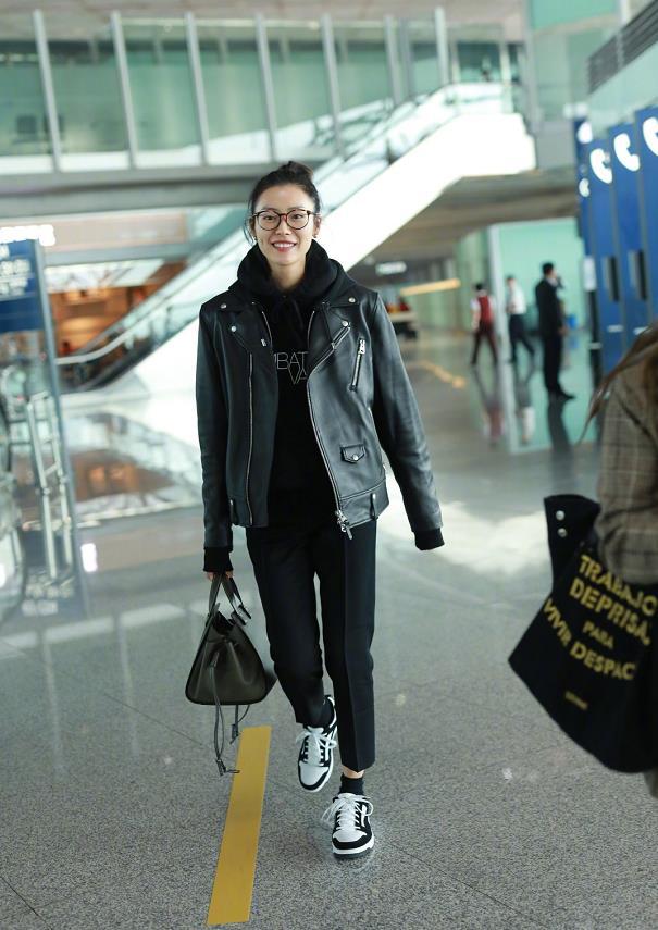 超模刘雯现身机场,身穿黑色机车夹克帅气十足,笑容满面酒窝迷人