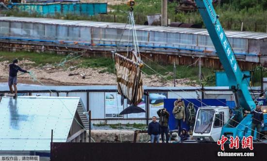  当地时间6月20日，俄罗斯，海参崴，工人们在斯雷德尼亚湾用起重机把鲸鱼移走。
