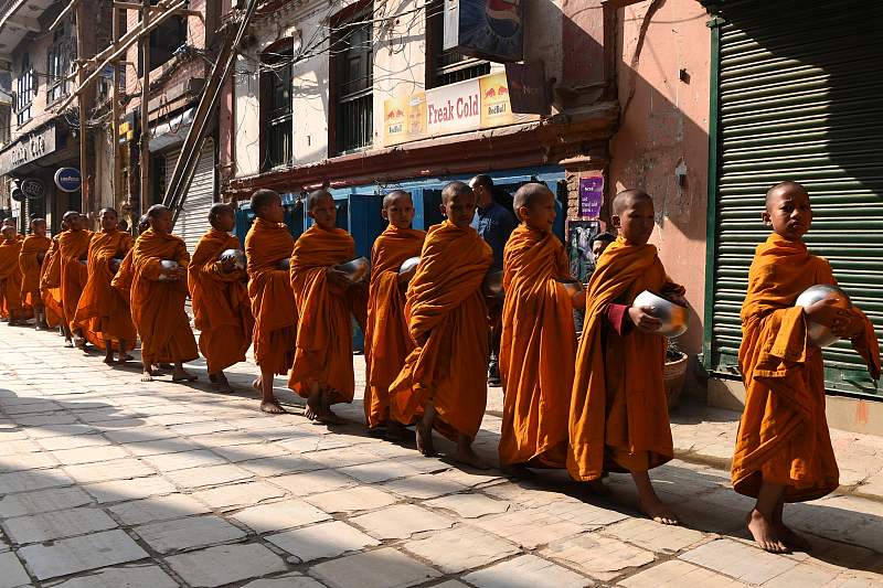 近日有摄影师在泰国街头拍到了一群小沙弥穿着统一的黄色僧袍,拿着银