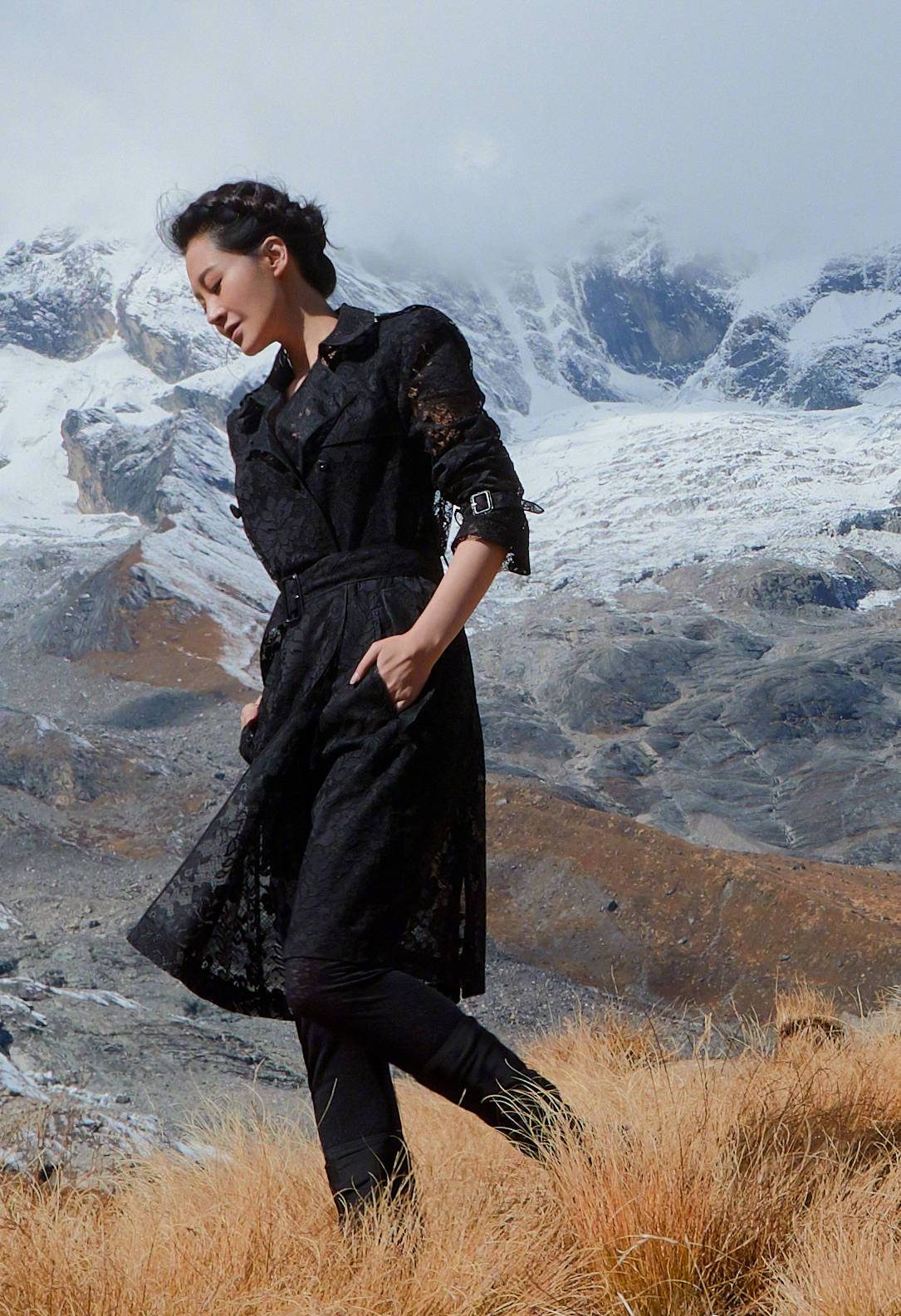 许晴雪山顶旅游不忘拍照,一身中国红大衣配长筒靴,50岁人比花娇