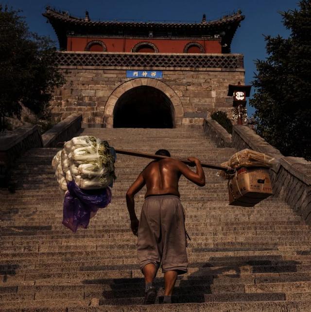 山顶上所有的吃食以及用品,都是你眼前这一位位皮肤黝黑的挑山工一步