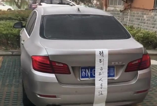 私家车位被宝马车占了,主人给这车贴了张"符",字写得还不赖