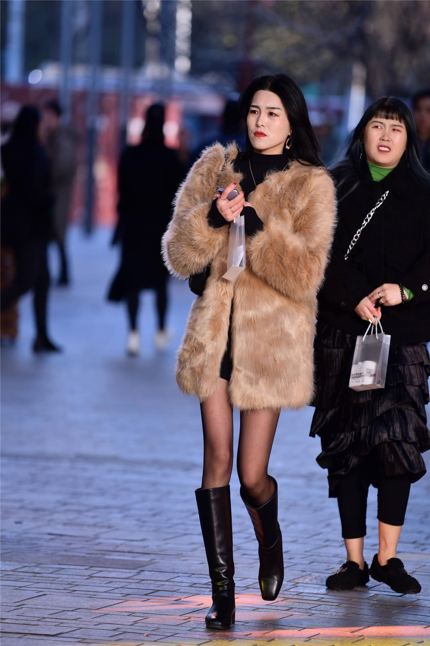 会让自己有着不一样的味道,这位美女选择白色的羊羔毛皮草,没有袖子的