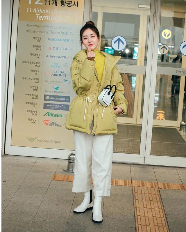 亮黄色羽绒服搭配同色调高领针织毛衣,长发挽成俏皮甜美的丸子头,宛如