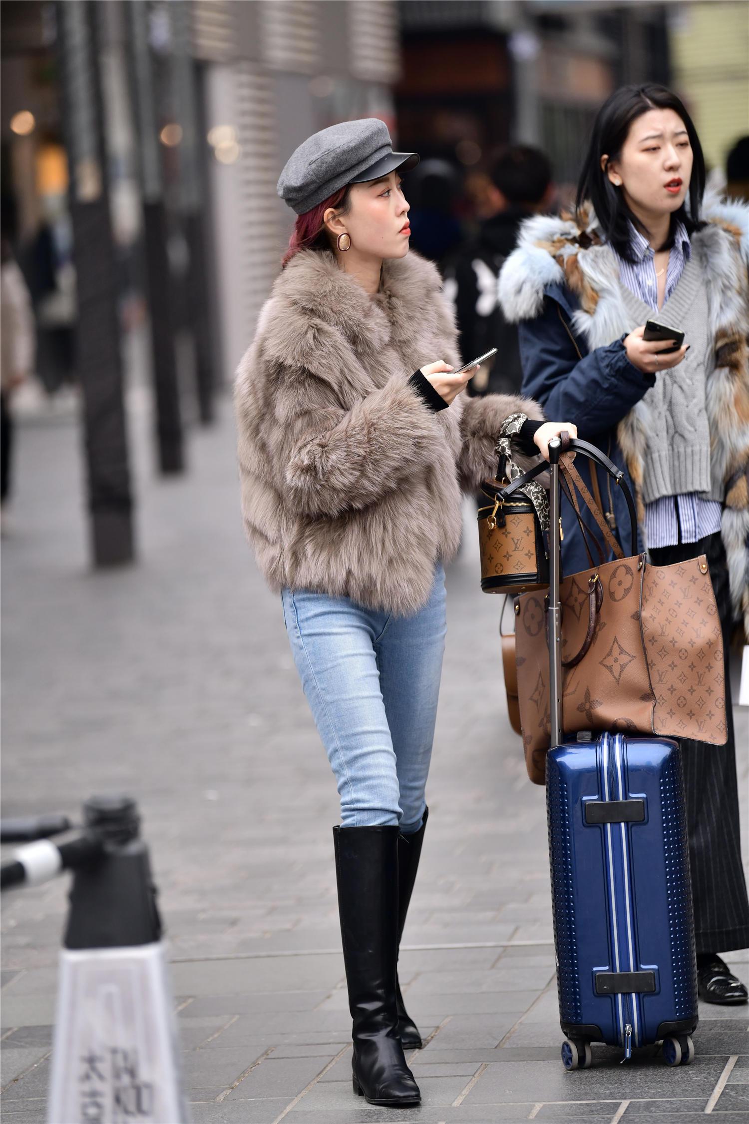 蓝色紧身牛仔裤,搭配黑色皮靴,皮草外套更显贵气