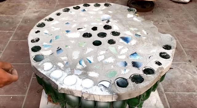 空啤酒瓶还好没扔掉,老爸用来做张桌子,造型别致放院子里很耐用