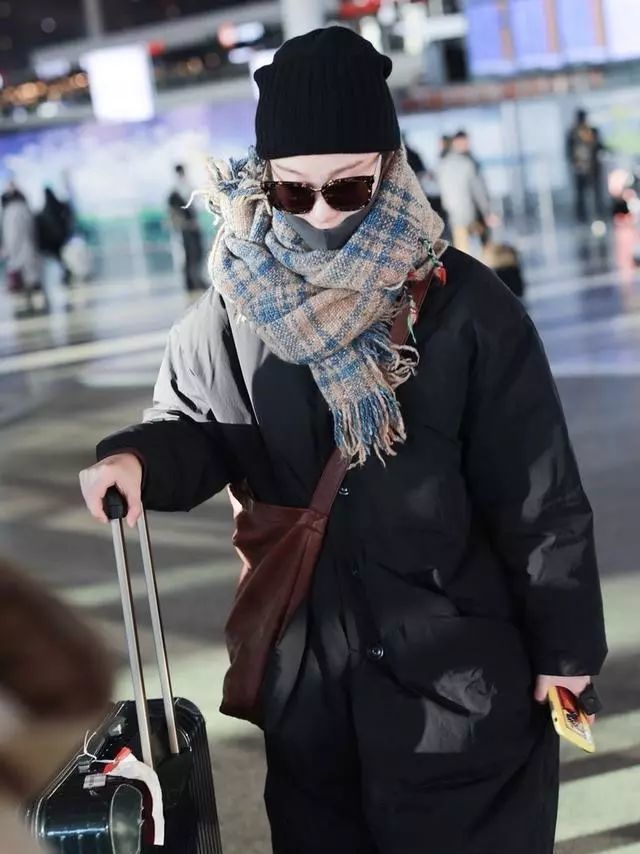 倪妮太美,长款羽绒服搭配牛仔裤,围巾把脸都遮住一半这个冬天真的是