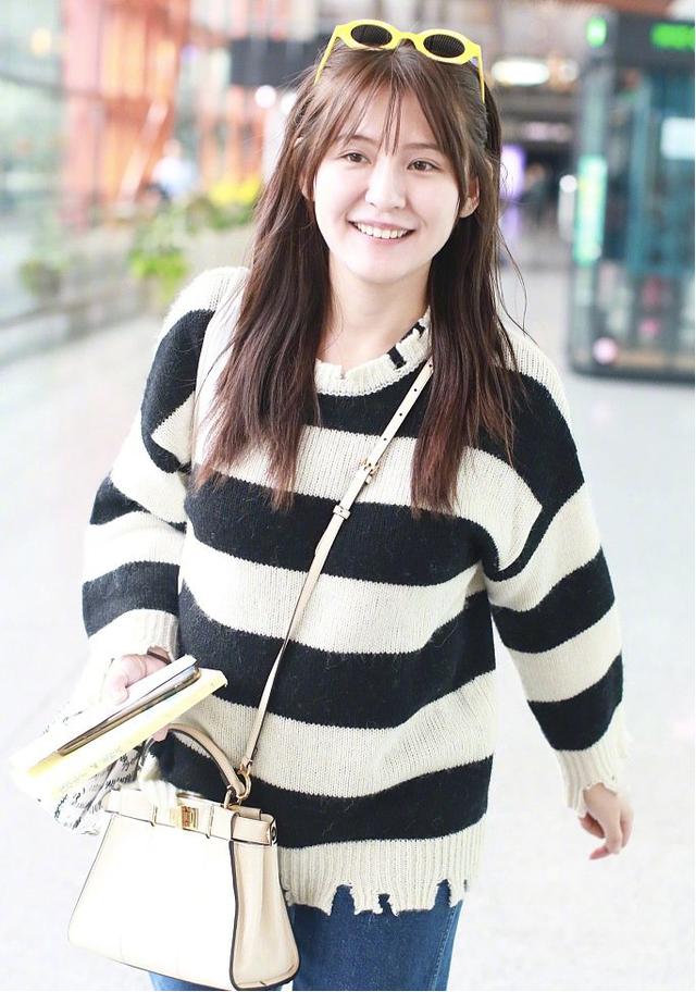 33岁热依扎现身机场穿基础款条纹针织衫搭配牛仔裤