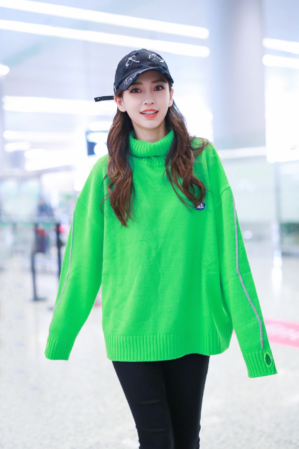 杨颖美成机场焦点,穿绿色针织衫戴鸭舌帽,笑容明媚少女感十足