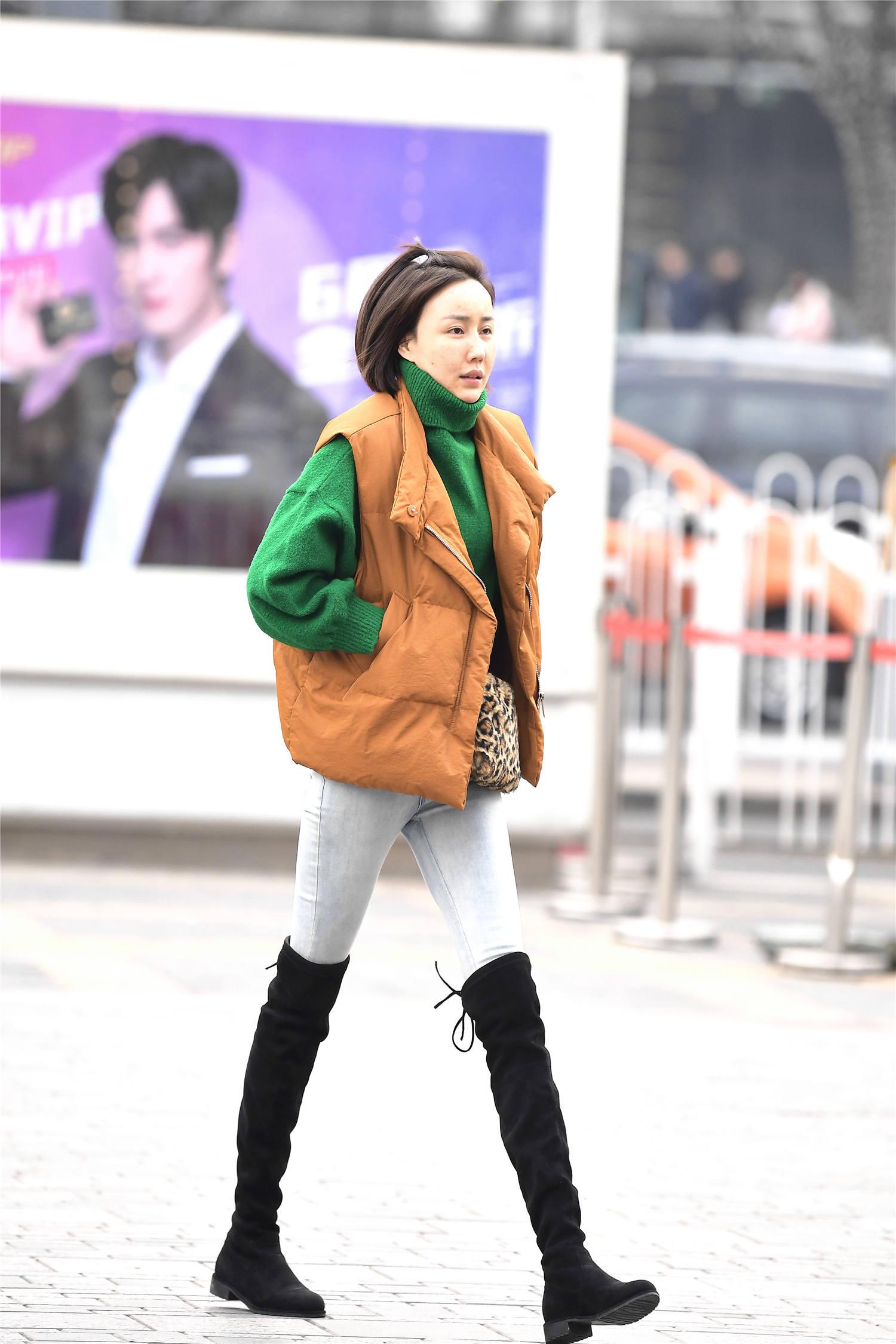 浅色牛仔裤搭配黑色过膝长靴,经典的冬季搭配,每年穿搭都不过时