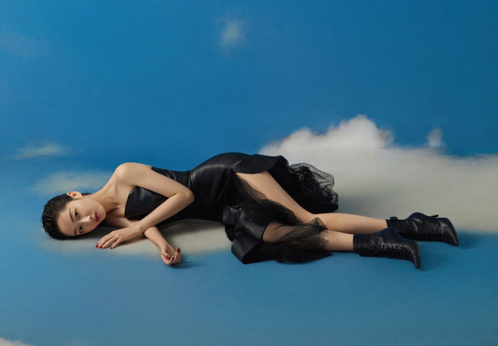 蒋梦婕趟地上凹造型,一袭黑色皮裙拼接轻纱,高开叉秀美腿超抢眼