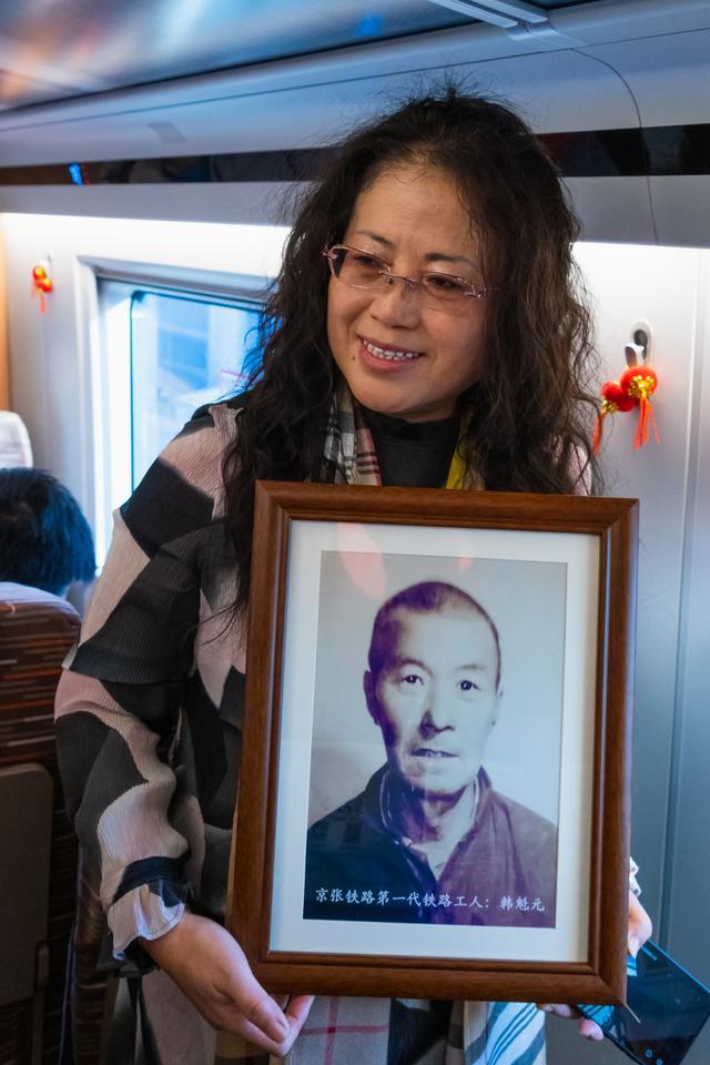韩永华的爷爷是第一代京张铁路建设者,她特意抱着爷爷的照片乘坐首发