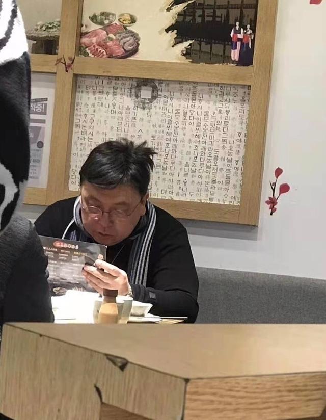 王晶外出吃饭被偶遇,头发凌乱低头玩手机很接地气