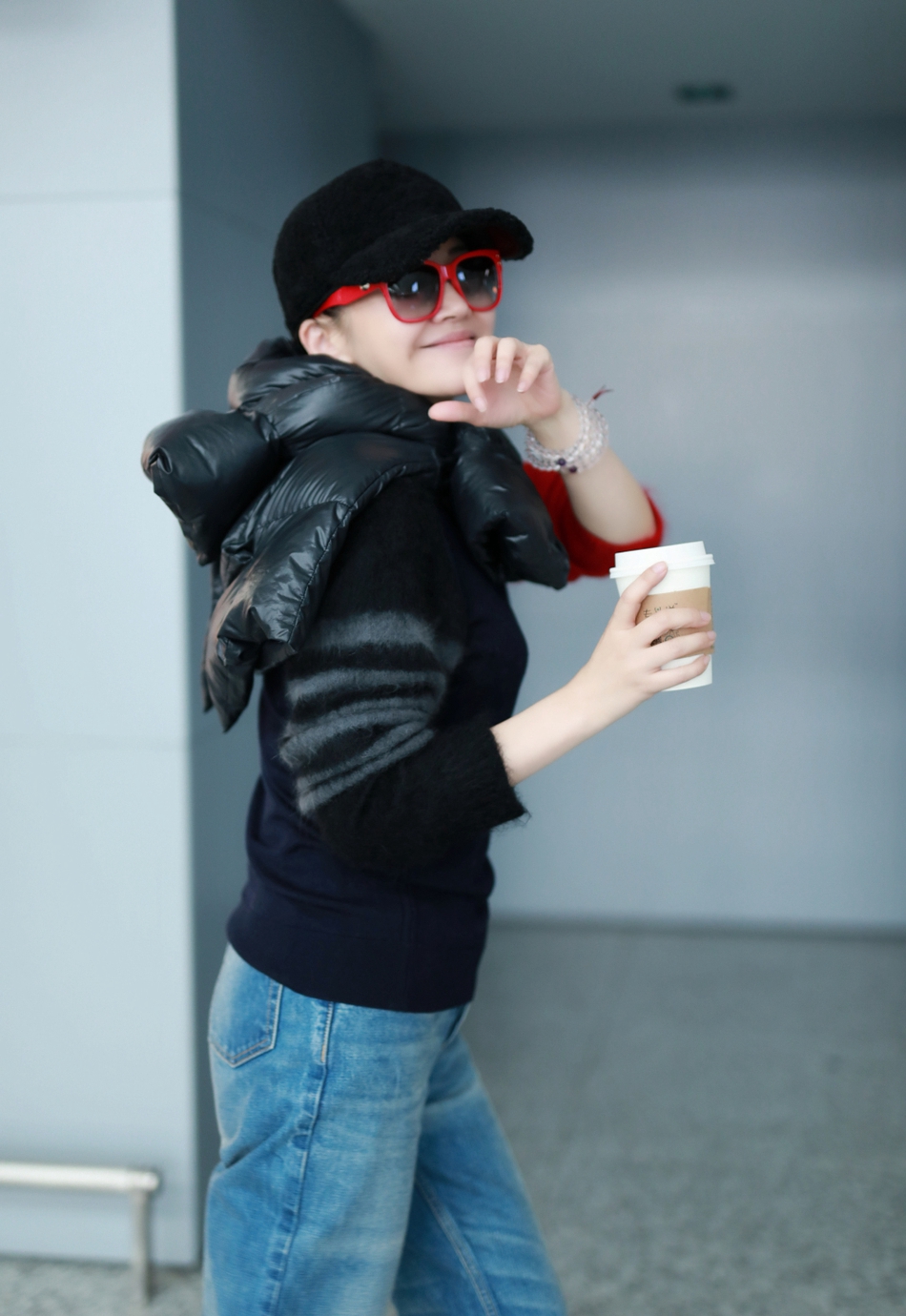 许晴现身机场,穿拼色毛衣有个性,棉服打个结系脖子上好时髦!