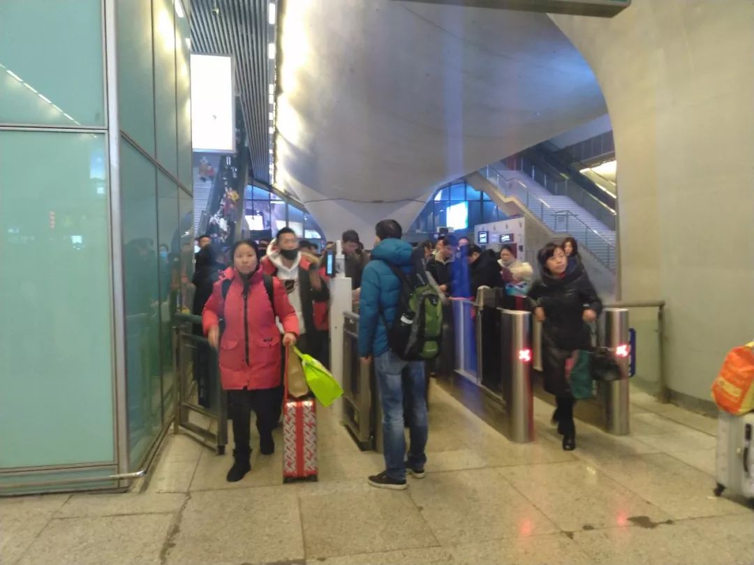  1月19日22时许，武汉高铁站出站闸机处，仅有不到三分之一的乘客佩戴了口罩。新京报记者海阳 摄