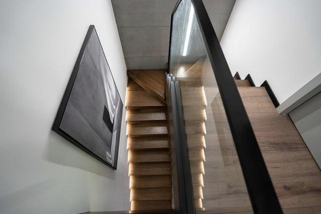 细节方面,下半部分的楼梯采用了钢结构和木饰面打造了悬空的效果,非常