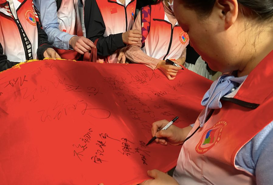 队员们在横幅上签字。新京报记者周小琪 摄