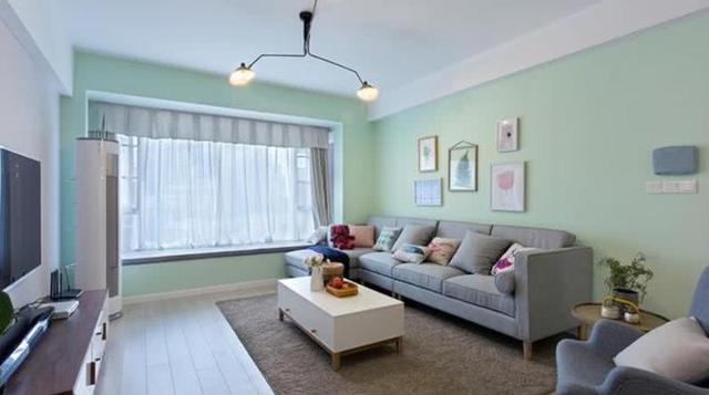 客厅的背景墙刷成了淡青色的,让整体看起来更加清新舒适,浅灰色的布艺