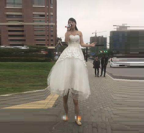 街头惊现两米高女巨人卖唱吸引不少路人眼光结果被人当众拆穿